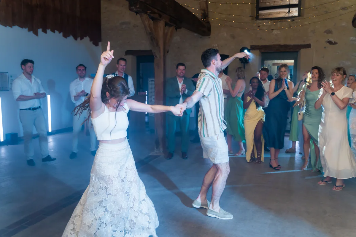 Dinah en Gerard dansen hand in hand op de dansvloer terwijl hun gasten om hen heen juichen
