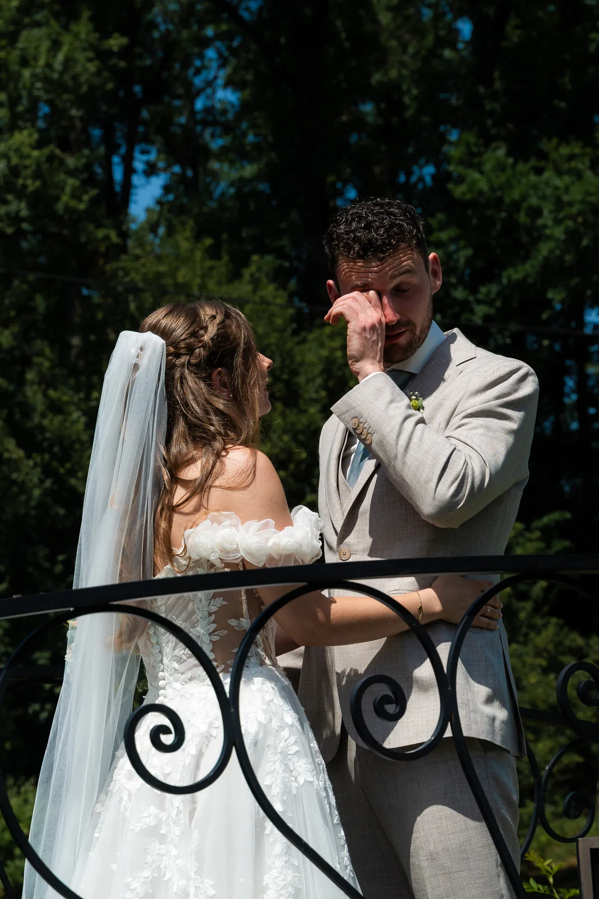 Dinah staat tegenover Gerard op een brug met smeedijzeren leuning; Gerard veegt een traan weg