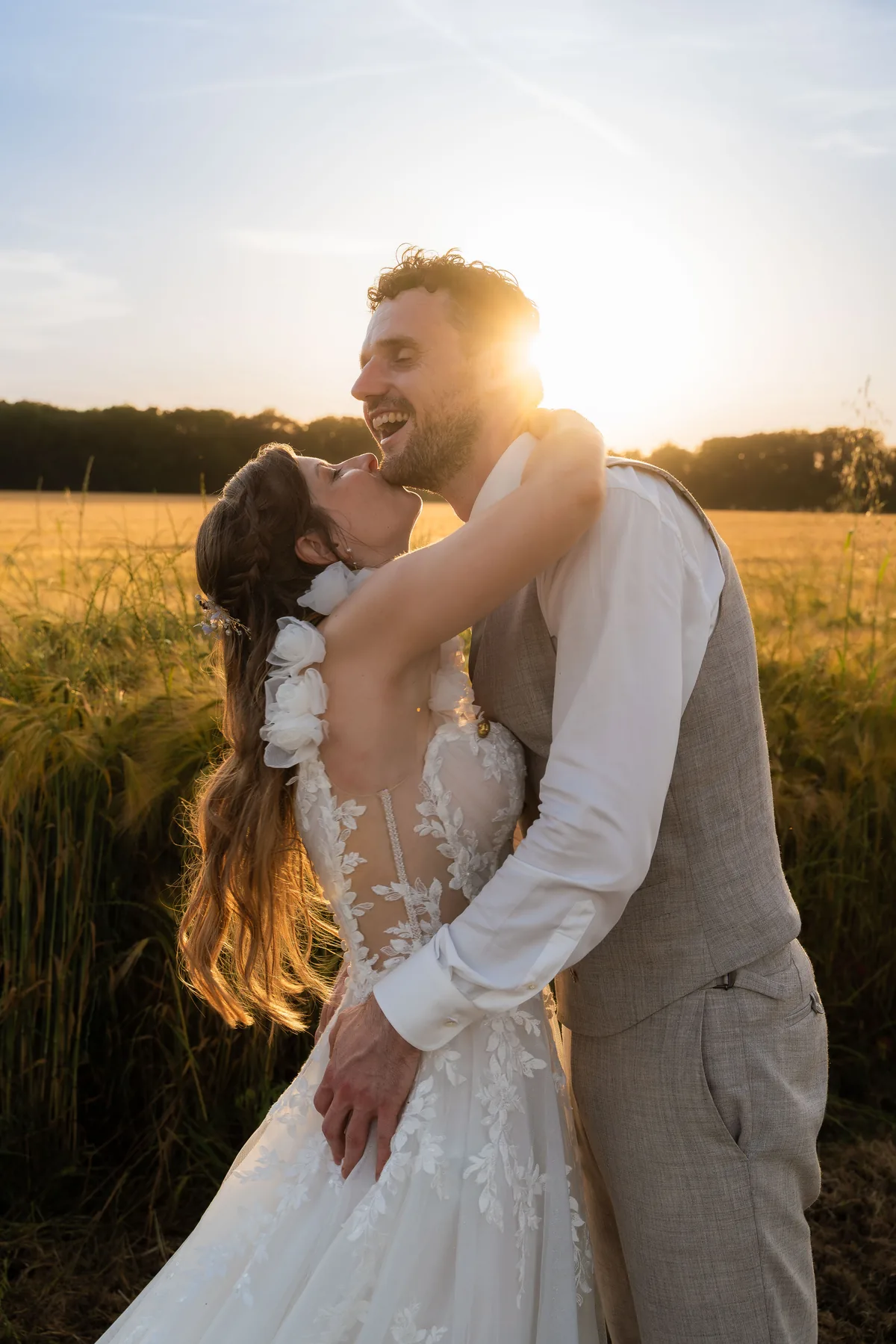 Dinah slaat haar armen om Gerard heen in een graanveld bij zonsondergang; Gerard lacht