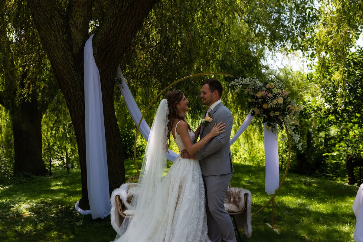 Henriko en Heidy tijdens de ceremonie op het gras onder grote wilgen
