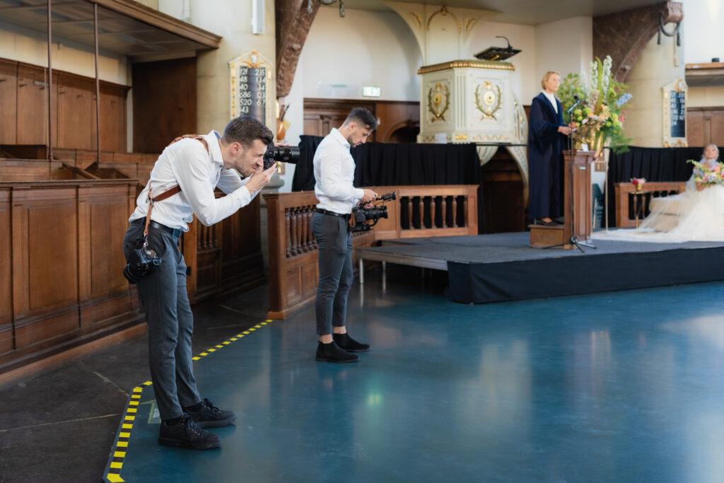Videograaf Marco en fotograaf Gijs van WeddingGuys leggen het bruidspaar vast tijdens de huwelijksceremonie