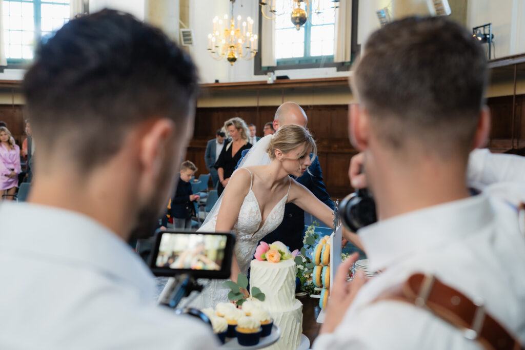 Videograaf Marco en fotograaf Gijs van WeddingGuys leggen het taart aansnij moment van het bruidspaar vast